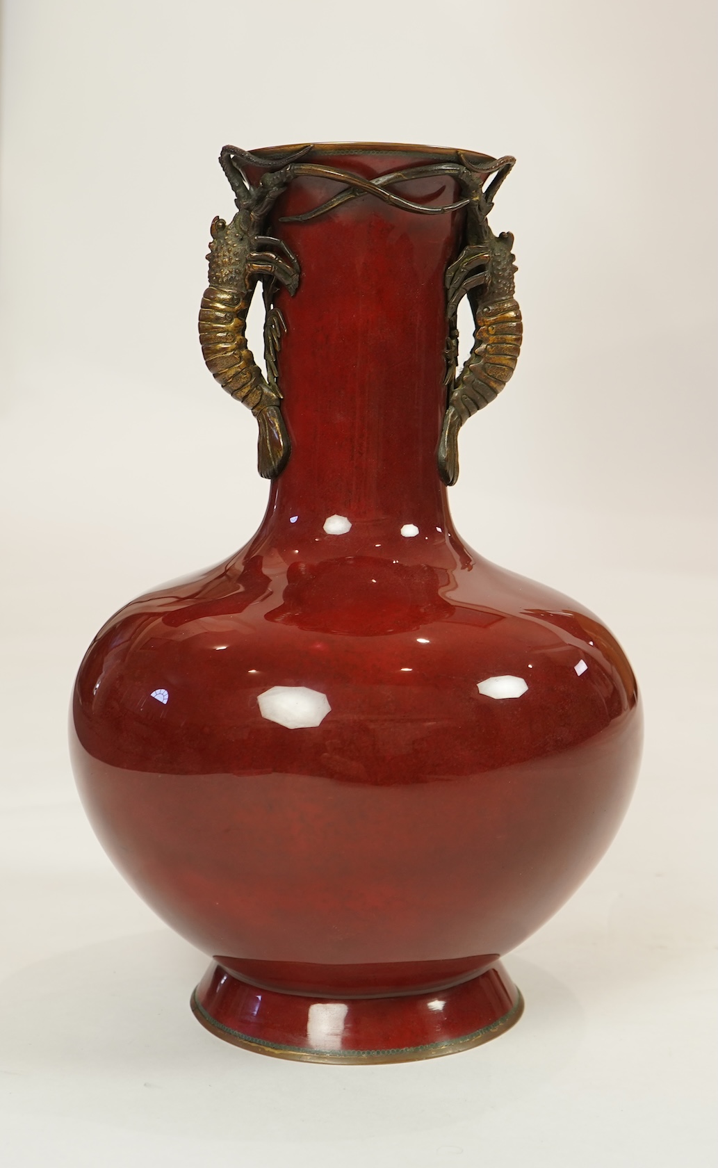 An unusual Japanese sang-de-boeuf ground cloisonné enamel and gilt metal mounted vase